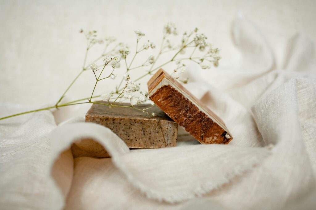 Elegant arrangement of handmade soaps with baby's breath on soft fabric.